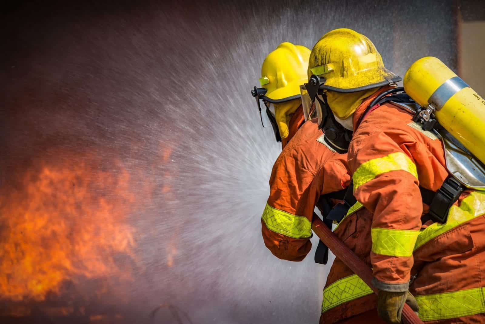 Firefighters Extinguishing Flames Stock Photo